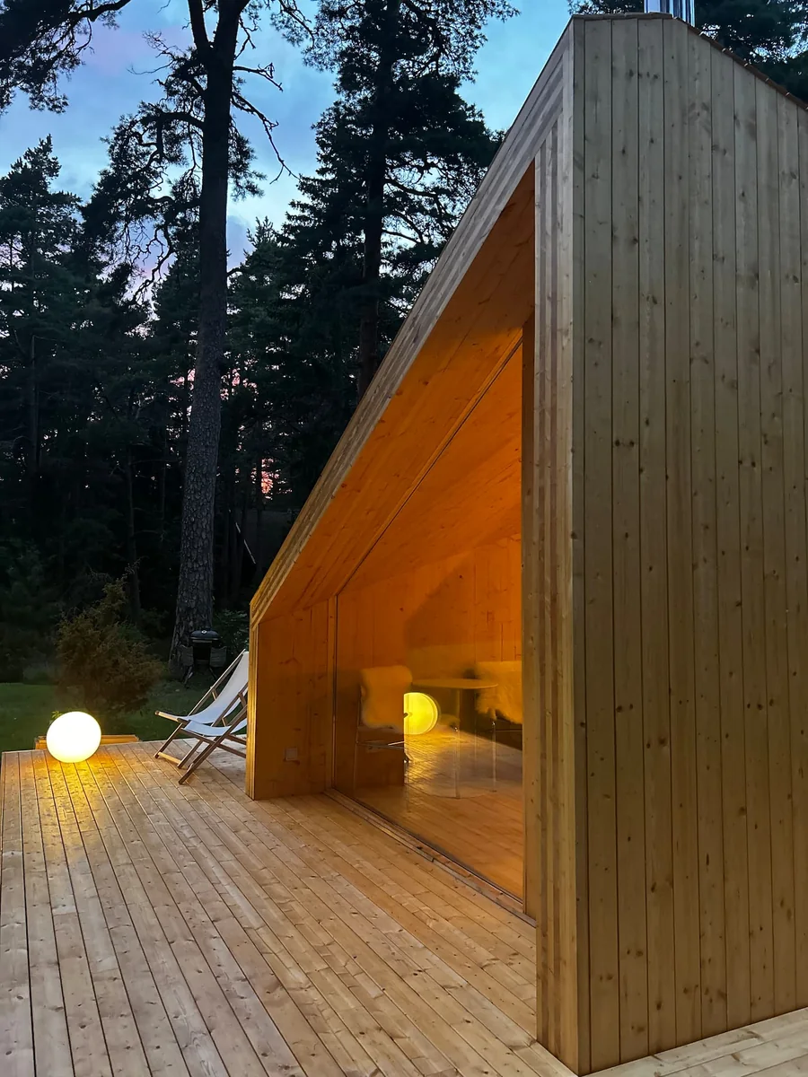 Etnika Zen's folded timber roof, glazed front and terrace at dusk