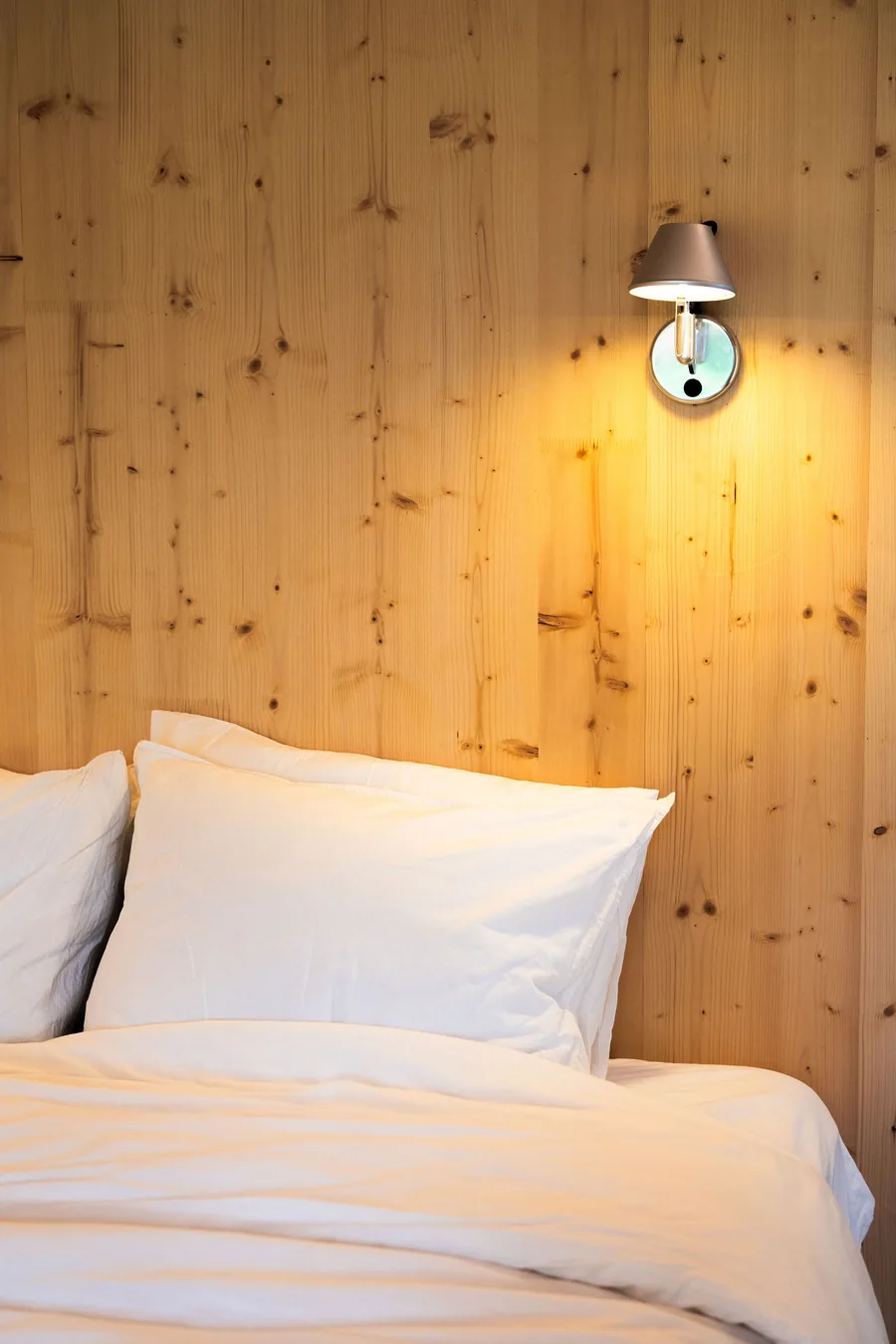 Zen sleeping area beneath the folded timber ceiling in soft natural light