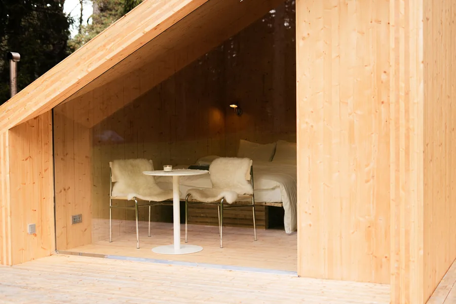 Etnika Zen's panoramic front window opening onto the covered terrace beneath the pines