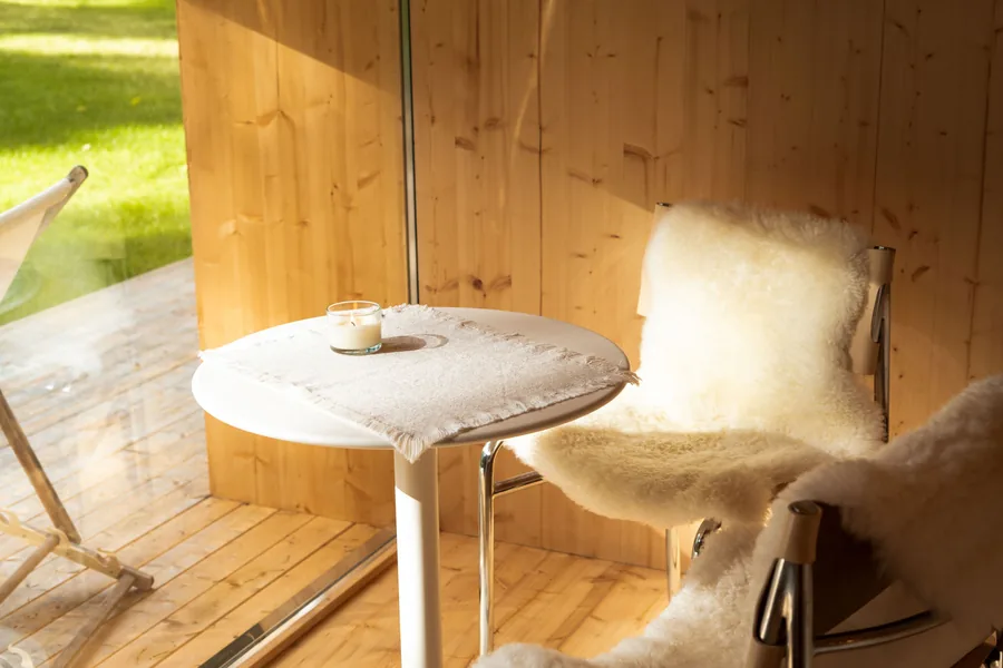 Sunlit Etnika Zen terrace with a table and lounge chair beneath the pines
